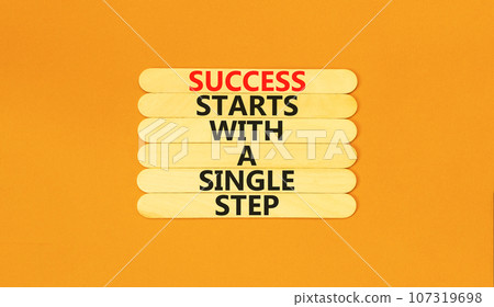Success symbol. Concept words Success starts with a single step on wooden stick. Beautiful orange table orange background. Business success starts with a single step concept. Copy space. 107319698