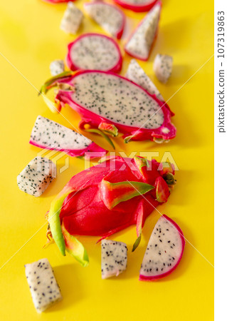 Slices of fresh white pitaya or dragon fruit on yellow background, flat lay Slices of fresh white pitaya or dragon fruit on yellow background, flat lay 107319863