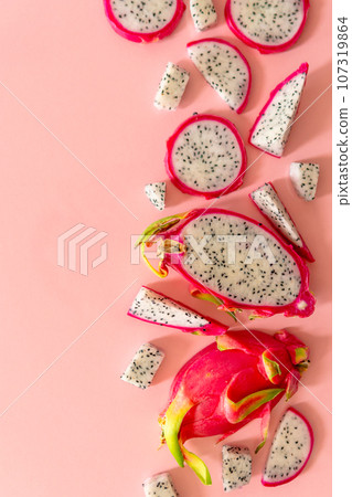 Slices of fresh white pitaya or dragon fruit on pink background, flat lay 107319864