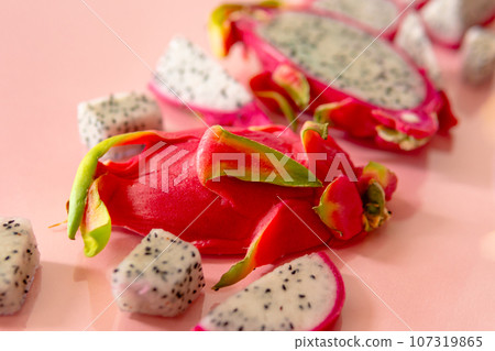 Slices of fresh white pitaya or dragon fruit on pink background, flat lay Slices of fresh white pitaya or dragon fruit on pink background, flat lay 107319865