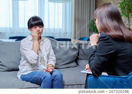 Mature woman at therapy meeting with psychologist Mature woman at therapy meeting with psychologist 107320296