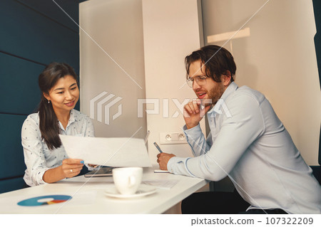 Two business colleagues working together with financial statements in stylish meeting room Two business colleagues working together with financial statements in stylish meeting room 107322209