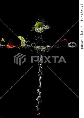 bright juicy fruits with splashes on black background. 107323031