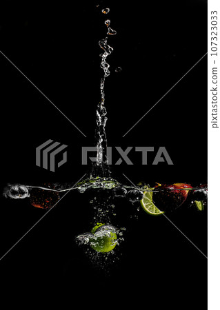 bright juicy fruits with splashes on black background. 107323033
