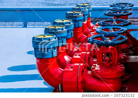 Five red fire hydrants on a fire line on a ship. 107323132