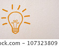 Abstract orange thinking light bulb on concrete wall background 107323809