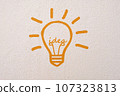 Abstract orange thinking light bulb on concrete wall background 107323813