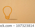 Abstract orange thinking light bulb on concrete wall background 107323814