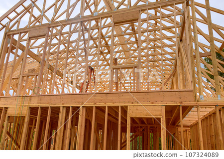 Construction work in progress an unfinished house with wooden framing beams view 107324089