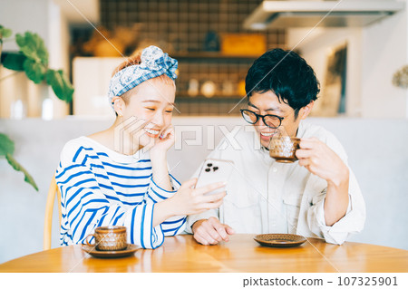 一起看智能手機的年輕夫婦 一起看智能手機的年輕夫婦 107325901