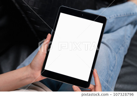 Woman hand holding digital tablet with blank screen for graphic display montage, in the living room. 107328796