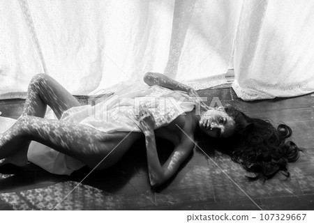 Naked Asian woman cover by fabric lying on floor by window Naked Asian woman cover by fabric lying on floor by window 107329667