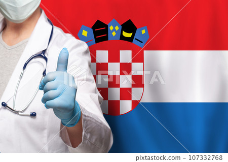Kroatian doctor's hand showing thumb up positive gesture on flag of Kroatia background 107332768