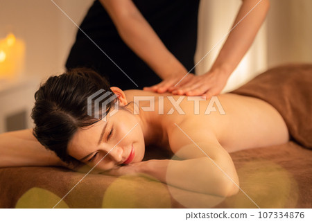 A middle-aged woman doing skin care at a beauty salon 107334876