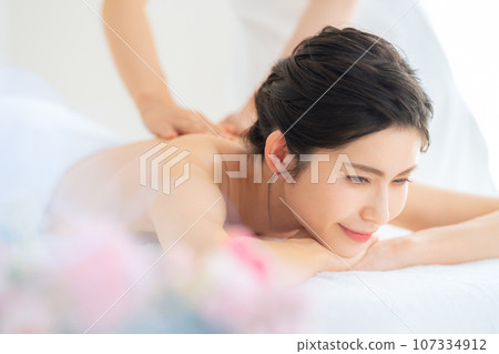 A middle-aged woman doing skin care at a beauty salon 107334912