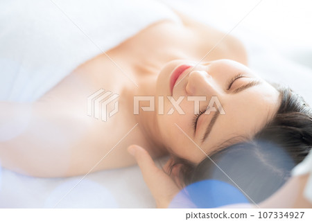 A middle-aged woman doing skin care at a beauty salon 107334927