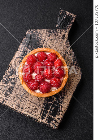 Delicious fresh sweet round tart with ripe raspberries and cream Delicious fresh sweet round tart with ripe raspberries and cream 107335770