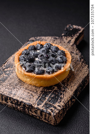 Delicious fresh sweet round tart with ripe blueberries and cream Delicious fresh sweet round tart with ripe blueberries and cream 107335784