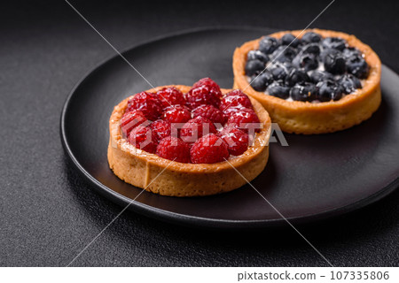 Delicious fresh sweet round tart with ripe raspberries and cream 107335806