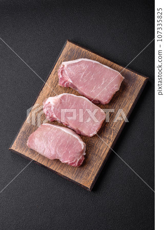 Raw fresh pork meat steak with salt, spices and herbs 107335825
