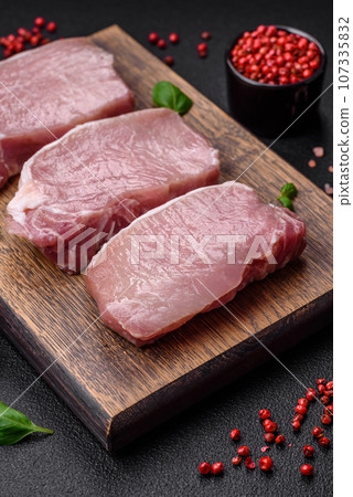 Raw fresh pork meat steak with salt, spices and herbs 107335832