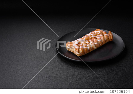 Delicious crispy braided bun with raisins inside and white icing outside Delicious crispy braided bun with raisins inside and white icing outside 107336194