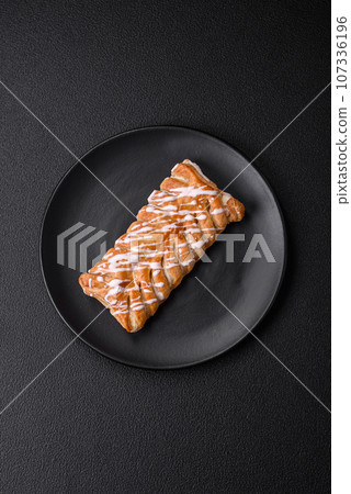 Delicious crispy braided bun with raisins inside and white icing outside Delicious crispy braided bun with raisins inside and white icing outside 107336196