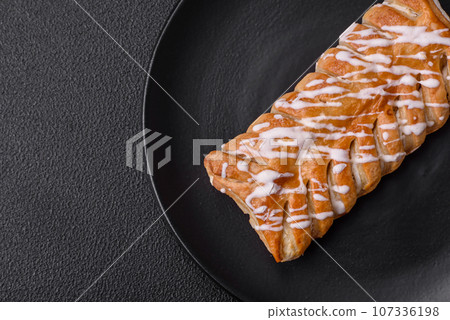 Delicious crispy braided bun with raisins inside and white icing outside Delicious crispy braided bun with raisins inside and white icing outside 107336198