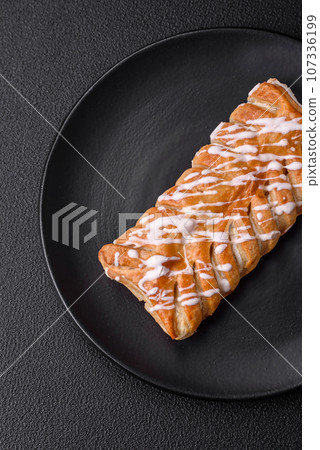 Delicious crispy braided bun with raisins inside and white icing outside Delicious crispy braided bun with raisins inside and white icing outside 107336199