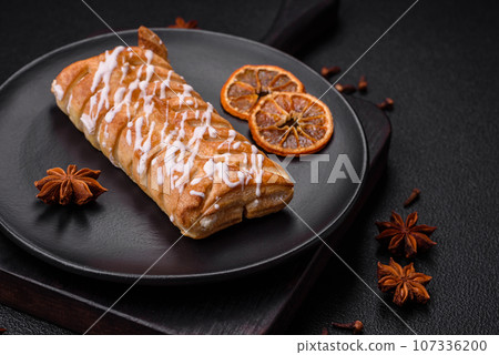 Delicious crispy braided bun with raisins inside and white icing outside Delicious crispy braided bun with raisins inside and white icing outside 107336200