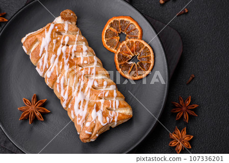 Delicious crispy braided bun with raisins inside and white icing outside Delicious crispy braided bun with raisins inside and white icing outside 107336201