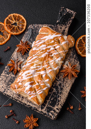 Delicious crispy braided bun with raisins inside and white icing outside Delicious crispy braided bun with raisins inside and white icing outside 107336208