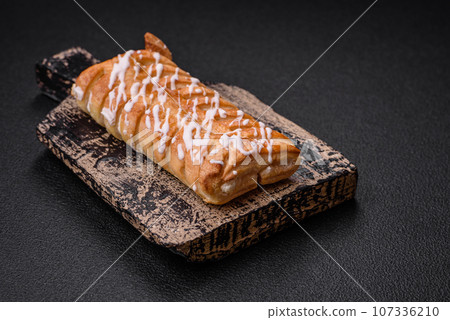 Delicious crispy braided bun with raisins inside and white icing outside Delicious crispy braided bun with raisins inside and white icing outside 107336210