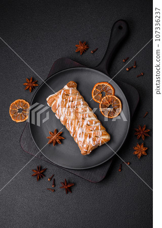 Delicious crispy braided bun with raisins inside and white icing outside Delicious crispy braided bun with raisins inside and white icing outside 107336237