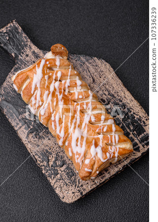 Delicious crispy braided bun with raisins inside and white icing outside Delicious crispy braided bun with raisins inside and white icing outside 107336239
