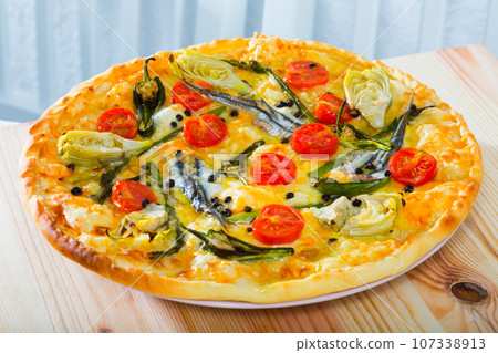 Pizza with anchovies, artichokes, cheese 107338913