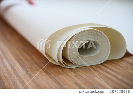 Close-up of a white roll of wallpaper. Close-up of a white roll of wallpaper. 107338988