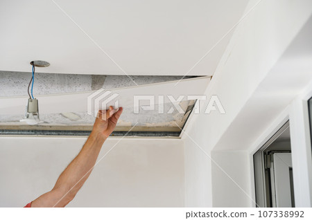 Worker assemble a suspended ceiling. Worker assemble a suspended ceiling. 107338992