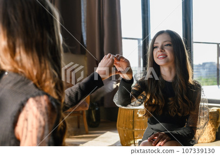 Teenage girl looking at her reflection in the mirror. 107339130