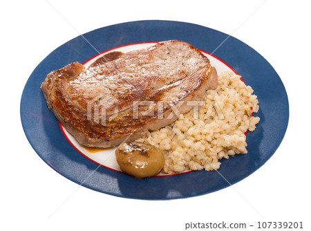 Barley groats with frying beef loin at plate on table, nobody 107339201