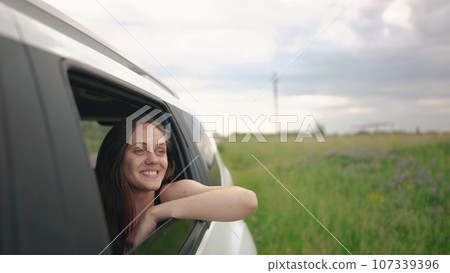 free girl hand from the window is driving a car, the wind is in her face. journey of a car on the road. the girl stretches out her hand from the car window. movement of driver hand lifestyle out free girl hand from the window is driving a car, the wind is in her face. journey of a car on the road. the girl stretches out her hand from the car window. movement of driver hand lifestyle out 107339396