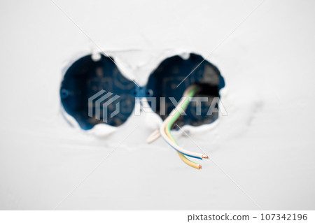 Electric wires in the socket box on wall 107342196