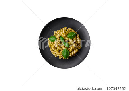 Delicious fresh pasta with green pesto sauce with basil Delicious fresh pasta with green pesto sauce with basil 107342562