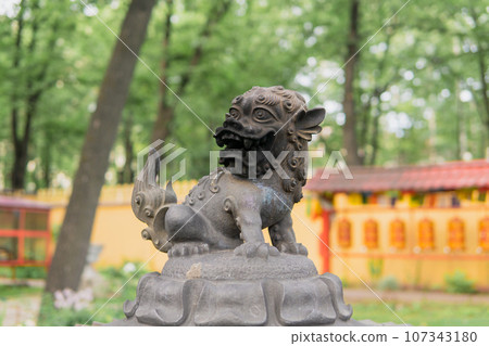 snow lion statue on top of a large bronze incense burner in the courtyard of a Buddhist datsan Gunzechoinei 107343180