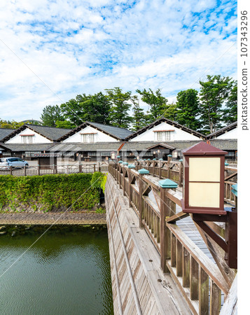 Beautiful Sankyo Warehouse historic building in Sakata city seen across the river during summer visit Beautiful Sankyo Warehouse historic building in Sakata city seen across the river during summer visit 107343296