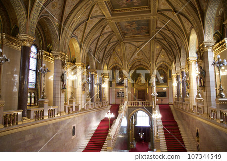 BUDAPEST, HUNGARY - MARCH 03, 2019: Magnificent staircase and dome inside the Budapest Parliament Building and seat of the Government of Hungary BUDAPEST, HUNGARY - MARCH 03, 2019: Magnificent staircase and dome inside the Budapest Parliament Building and seat of the Government of Hungary 107344549