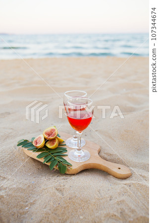 white cape, glasses on a wooden board and sand. Summer picnic close-up 107344674