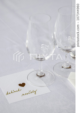 Wedding table with detail of glasses, cutlery and signs with name tags in the Czech language Wedding table with detail of glasses, cutlery and signs with name tags in the Czech language 107344960