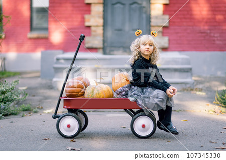 Beautiful girl witch. little girl in which costume celebrate Halloween outdoor and have fun. Kids trick or treating Beautiful girl witch. little girl in which costume celebrate Halloween outdoor and have fun. Kids trick or treating 107345330