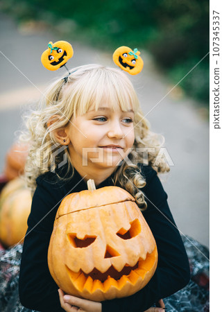 Beautiful girl witch. little girl in witch costume celebrate Halloween outdoor and have fun. Kids trick or treating Beautiful girl witch. little girl in witch costume celebrate Halloween outdoor and have fun. Kids trick or treating 107345337